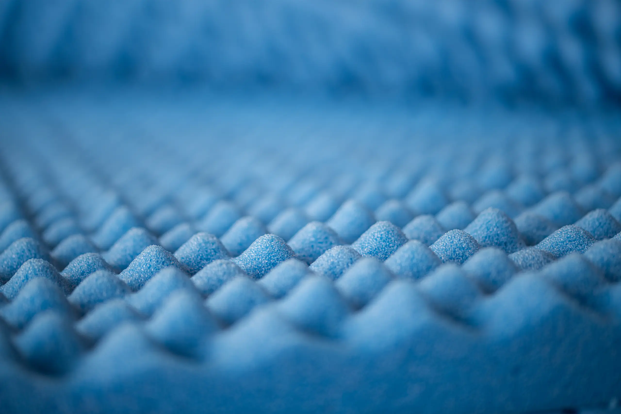 Dettaglio di materiale plastico flessibile blu bugnato.